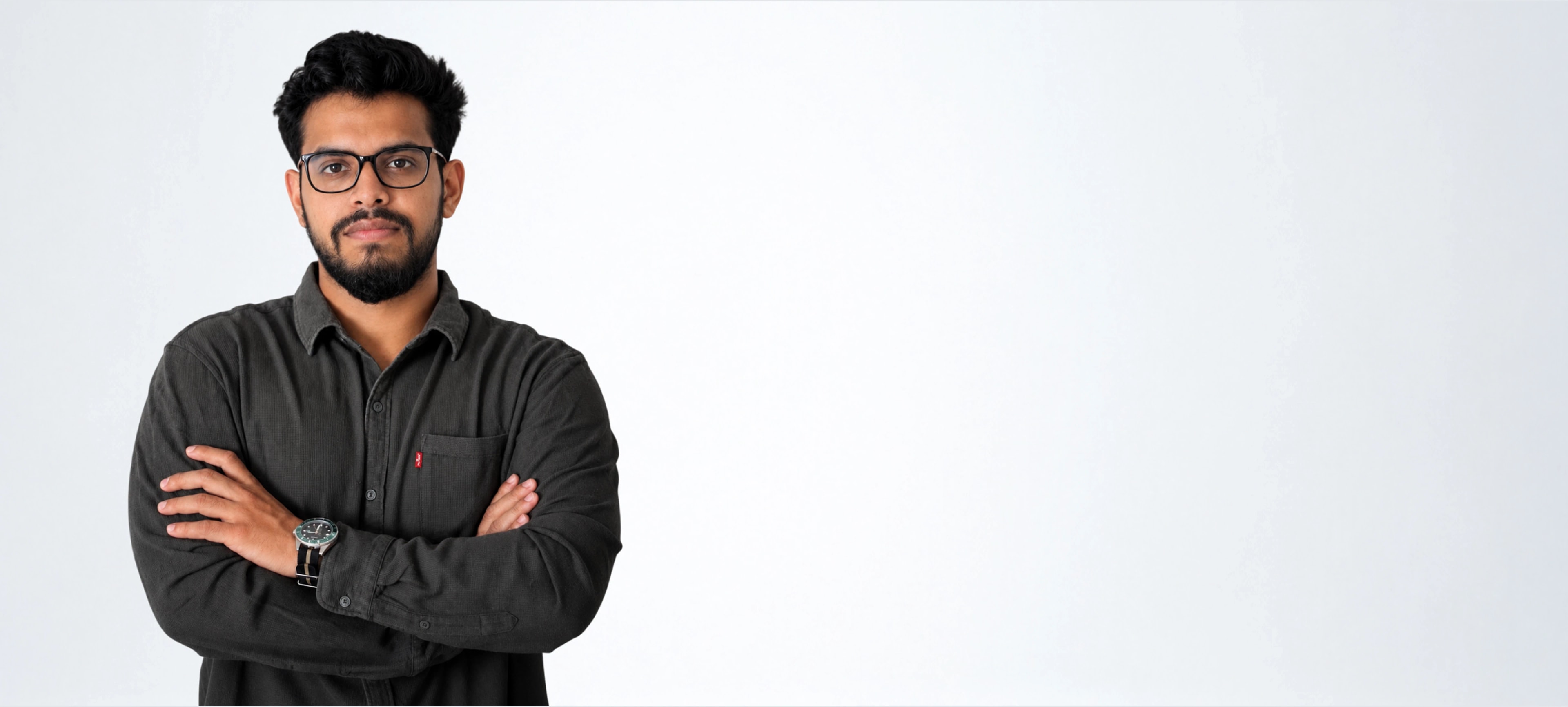 Portrait of Akash Singh, arms crossed, against a light grey wall