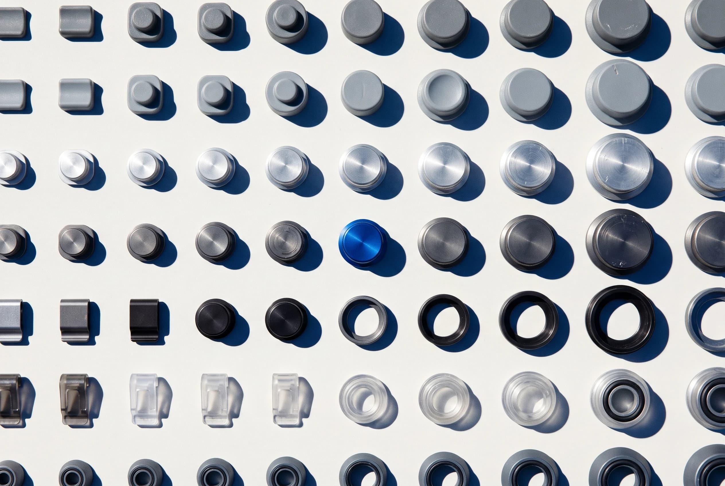 Rows of knobs and caps in graded sizes and finishes, one in blue