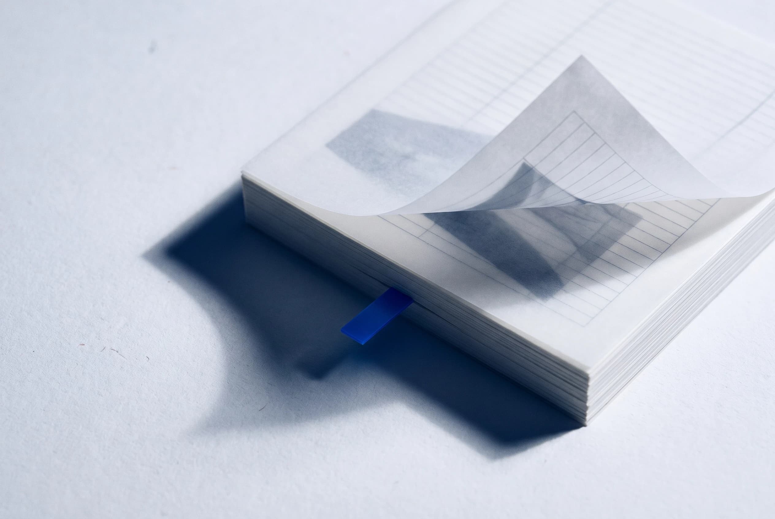 An open ruled notebook with a blue tab marking a page
