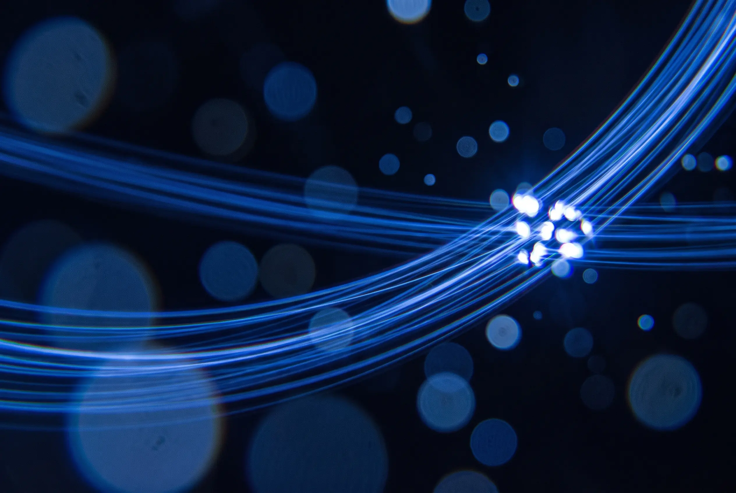 Strands of blue light converging on one bright point, with soft bokeh behind