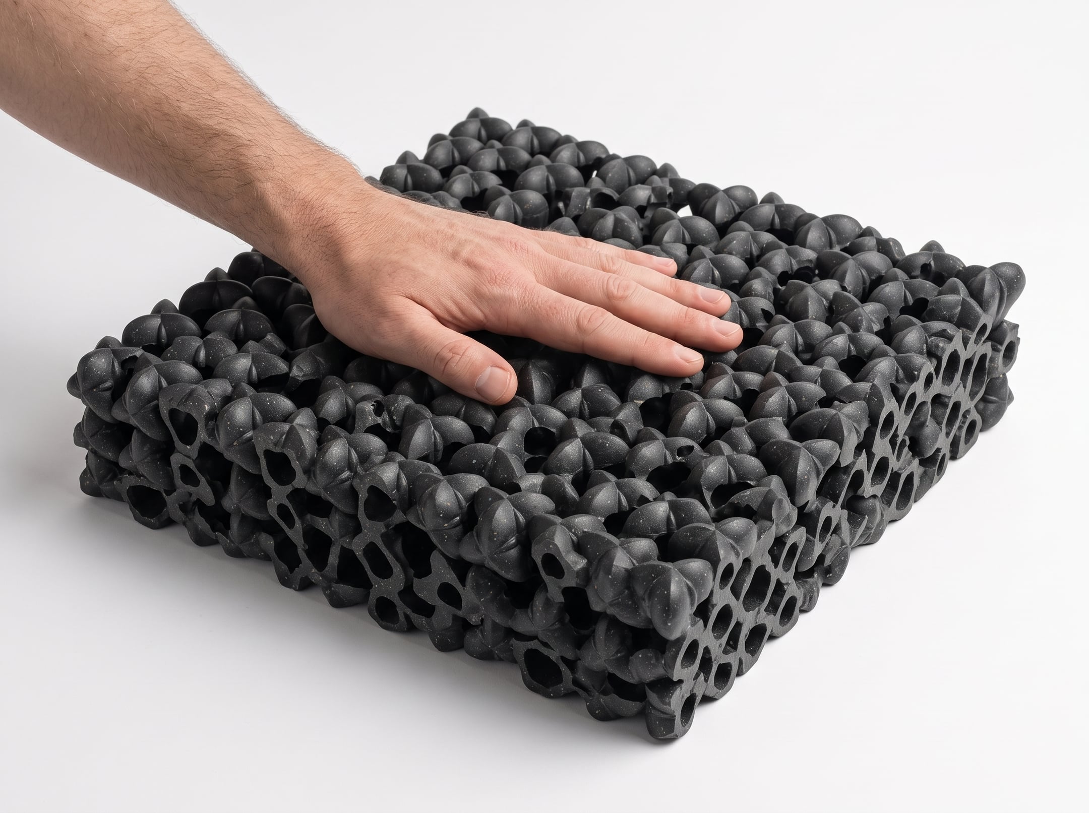 Render of a hand resting on a bonded slab of Oberon modules whose cut edge shows open channels running through it